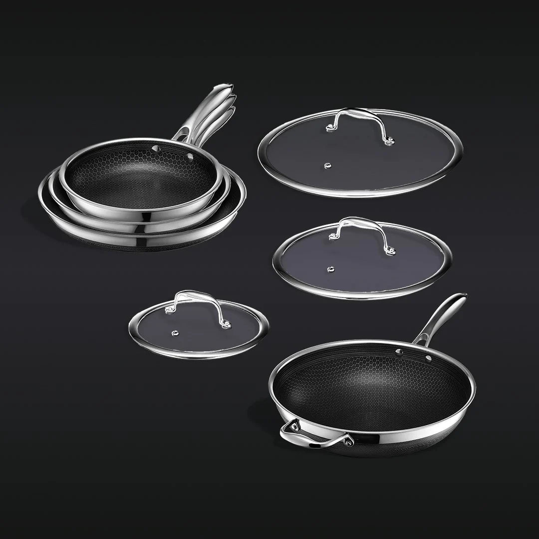 Hexclad stekepannesett, 3 panner og 1 wok med lokk. Sølv stål og mørkt non-stick sekskantmønster.