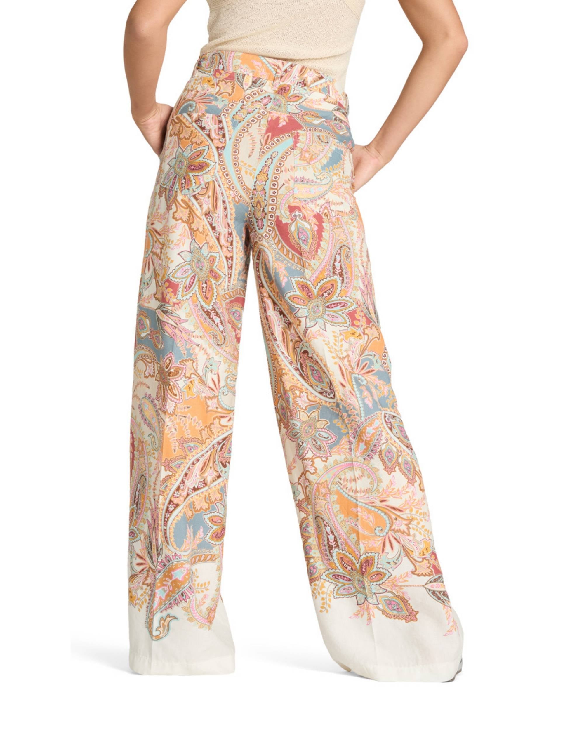Cambio Adrienne bukse med fargerikt paisley-print på kvit bunn, sett bakfra med synleg midjeparti og utståande bein
