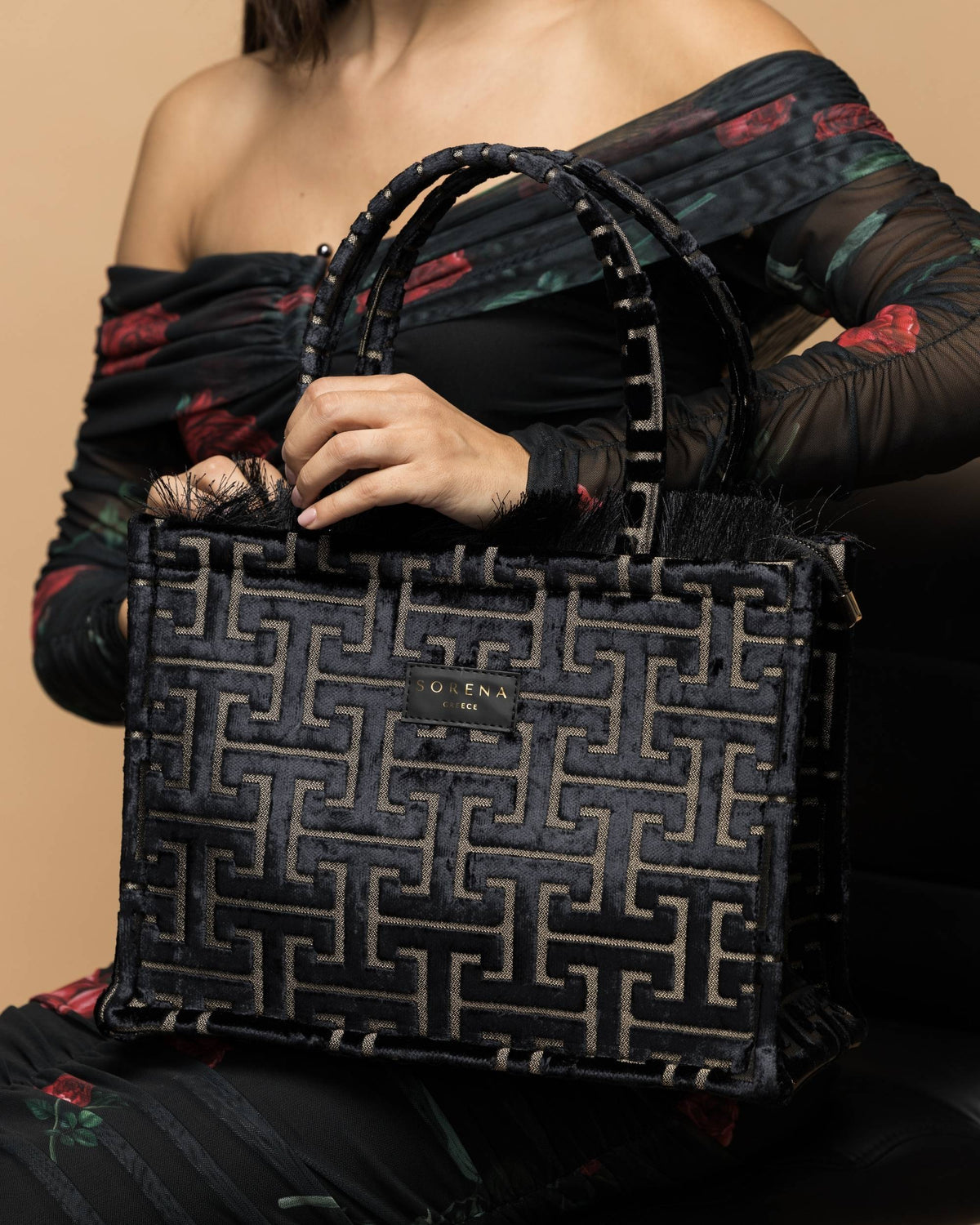 Sorena Andro Medium Tote Bag i svart fløyel med gullfarget abstrakt motiv, holdt av en person
