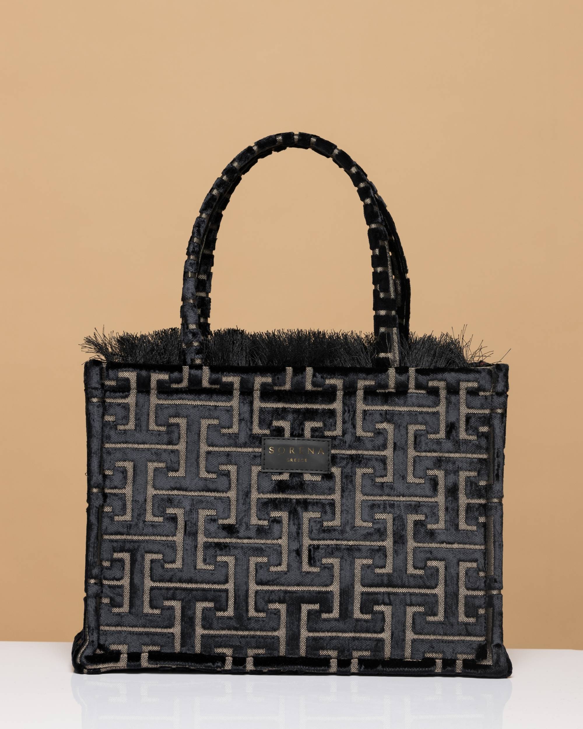 Nærbilde av Sorena Andro Medium Tote Bag i svart fløyel med gullfarget abstrakt labyrintmønster og duskekant.