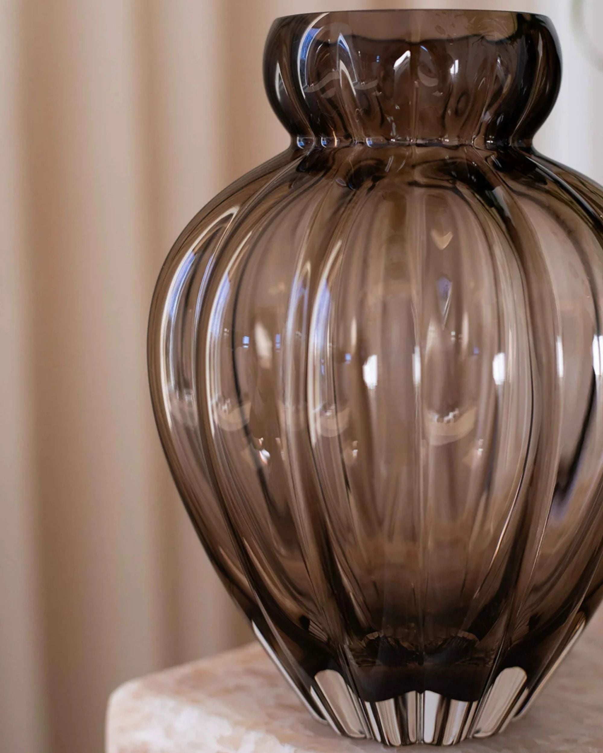 Specktrum Audry vase i brunt riflet glass, glatt hals, minimalistisk design, på beige marmorplate