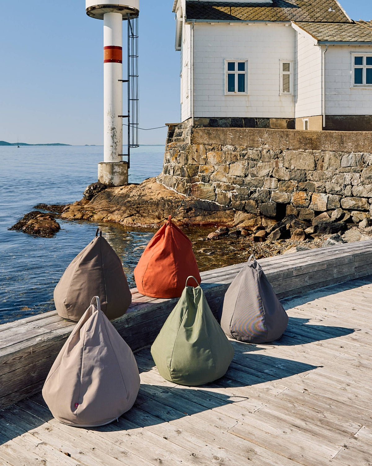 Fiam Bean Bag saccosekker i olivengrÞnn, grÄ, beige og oransje pÄ bryggekant ved sjÞen i sommerlys