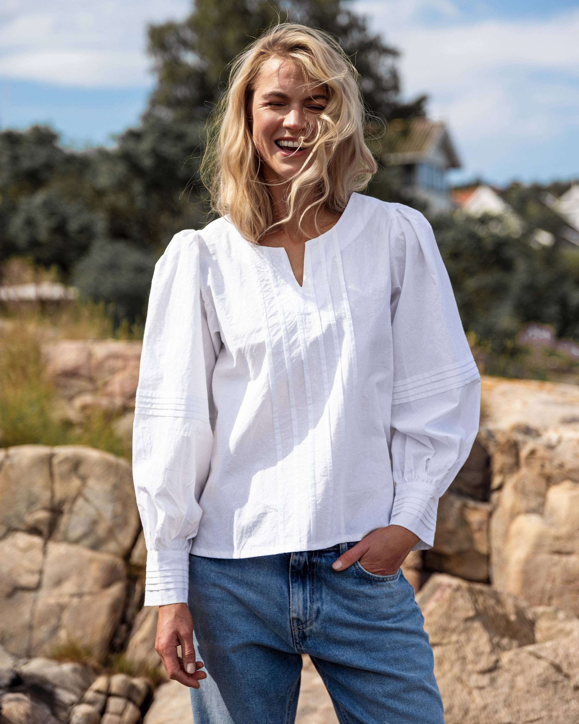 Modell med Close to My Heart Elena bluse, hvit bomullsskjorte med rynker og v-hals, foran fjellandskap