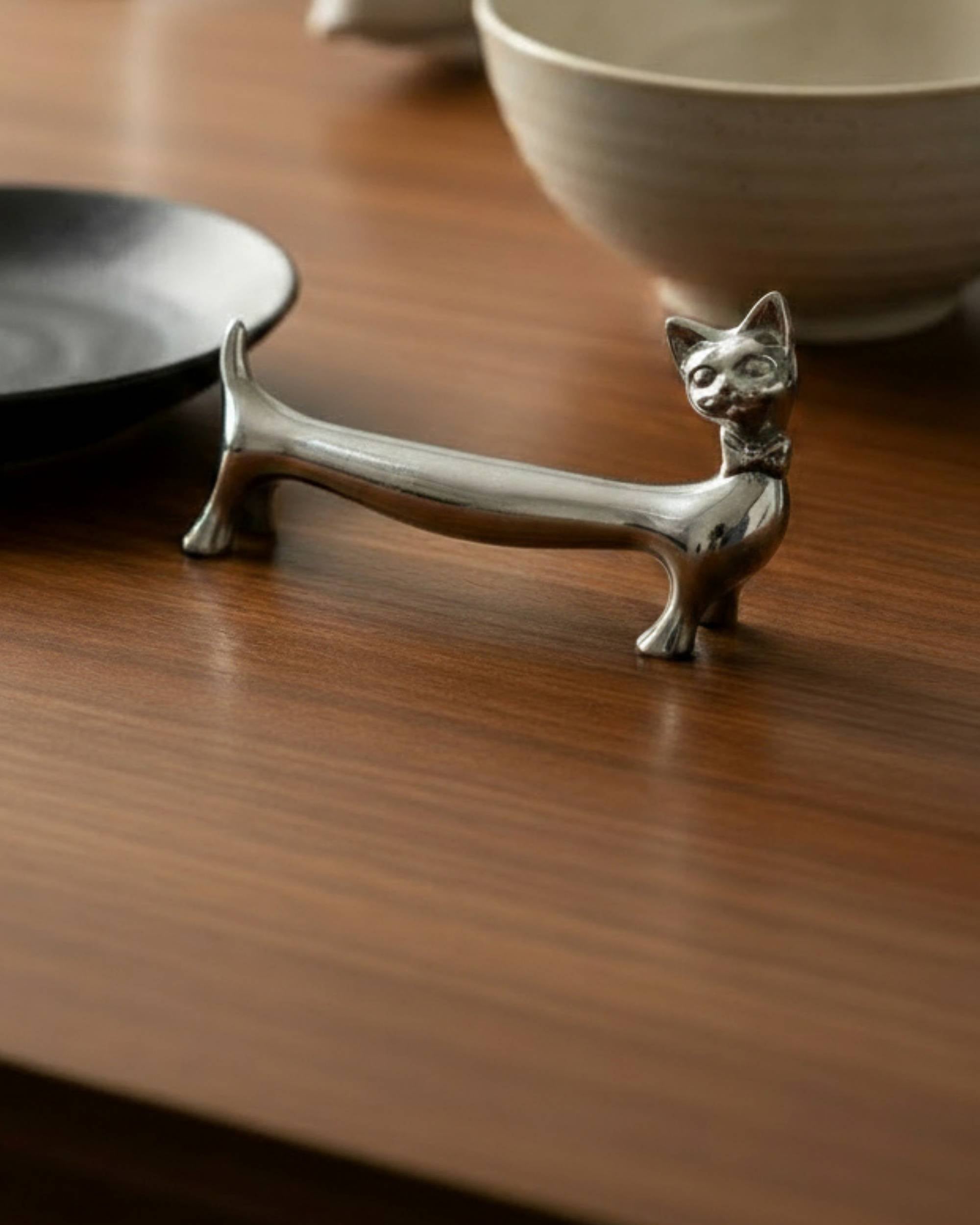 Reflekta KATT bestikkhviler i skinnende rustfritt stål, formet som katt, sett i borddekking med keramikk