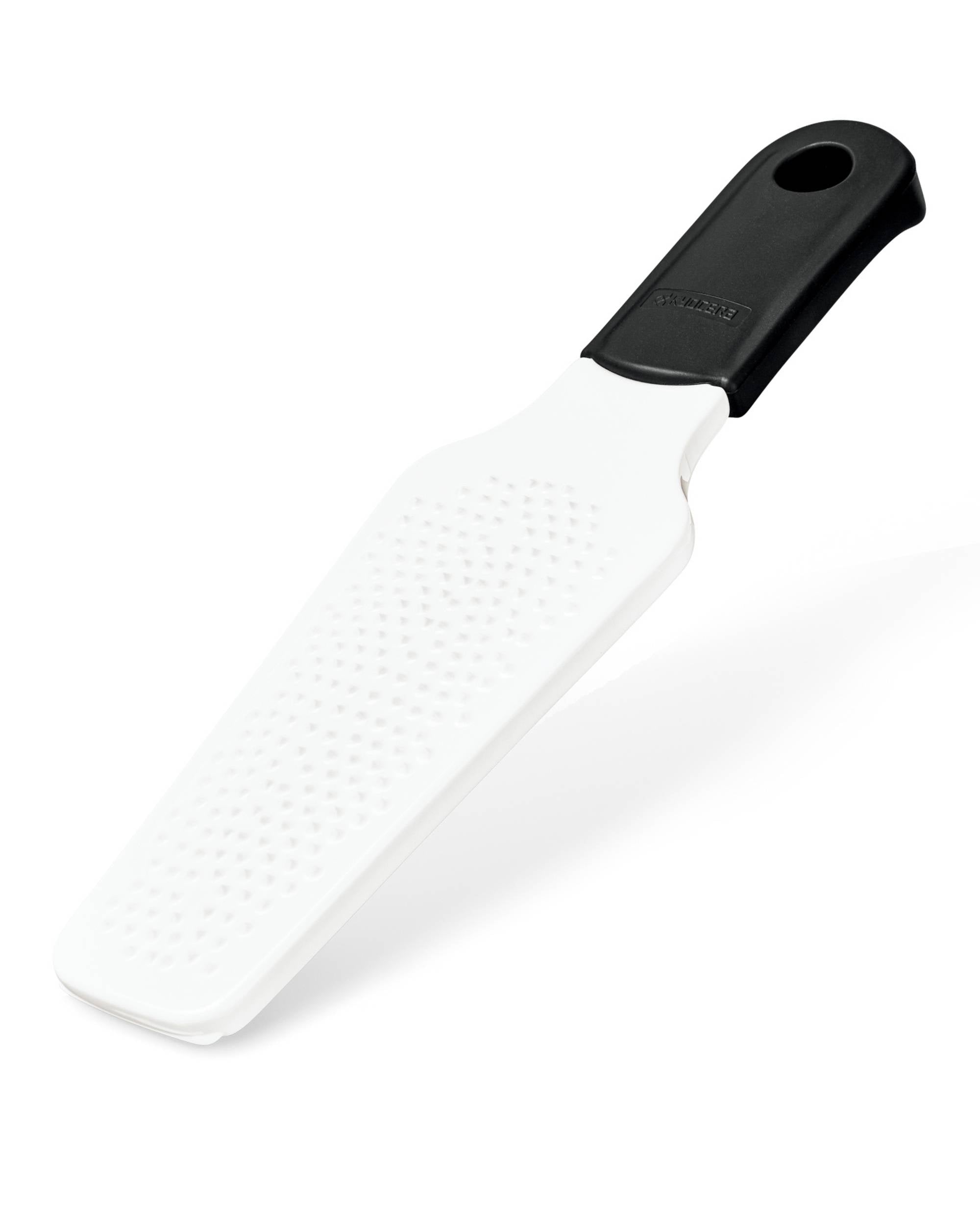 Kyocera rivjern i hvit keramikk med svart sklisikkert håndtak, avlang form, fin riveflate for ingefær/hard ost