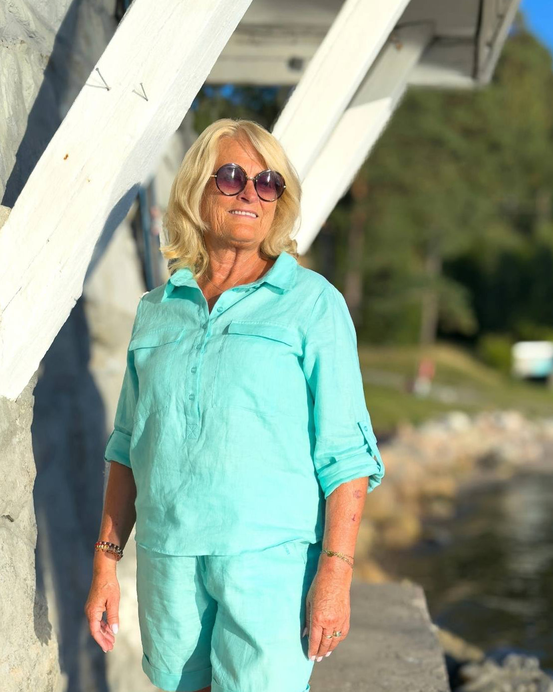 Libby Skjorte Aqua fra Close to My Heart i turkis lin, med oppbrettede ermer og to brystlommer. BĂŠres av modell.
