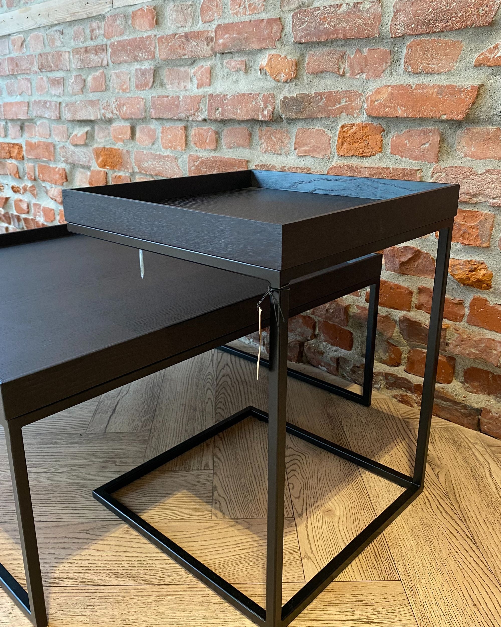 Jan Kurtz Pizzo sidebord, to svarte bord med treplate og metallramme, mot mursteinsvegg og tregulv.