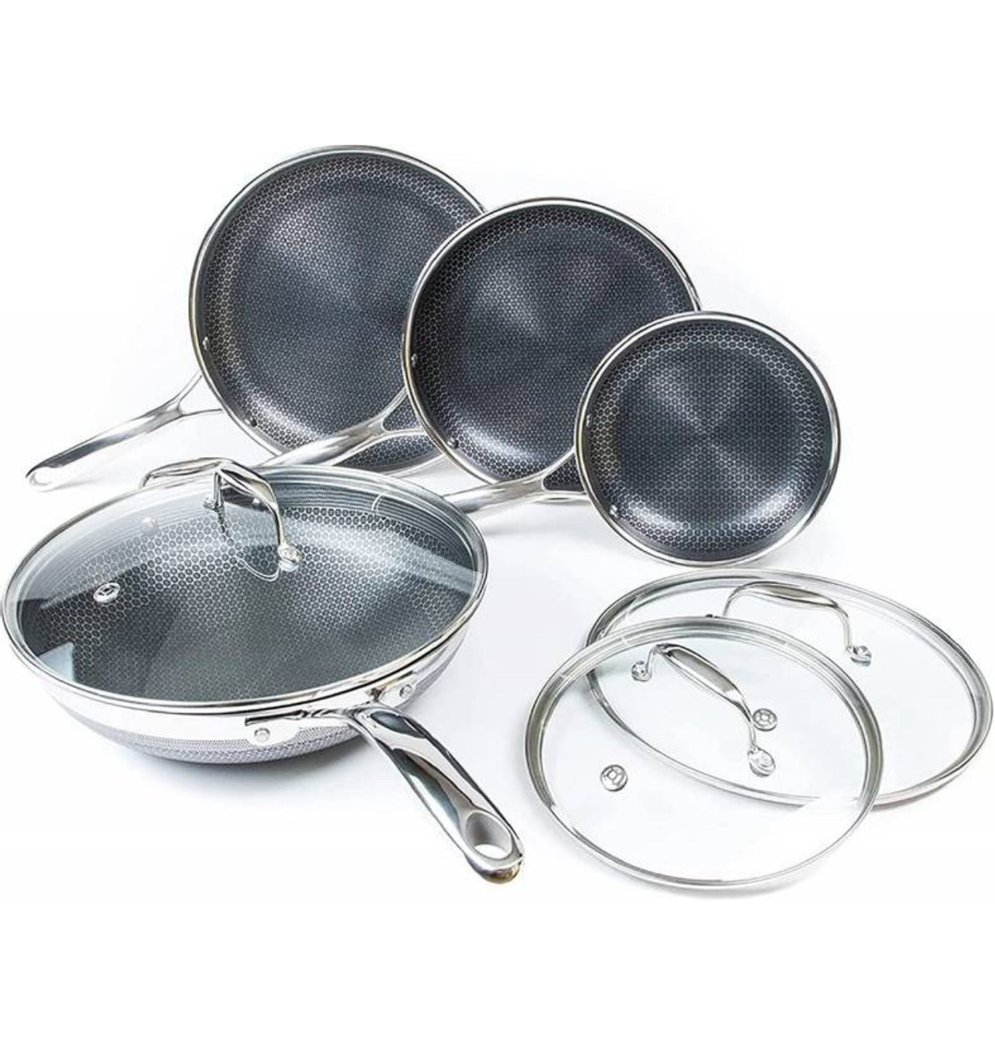 Hexclad stekepannesett i rustfritt stål, tre stekepanner og en wok, alle med sort bikakemønster og glasslokk