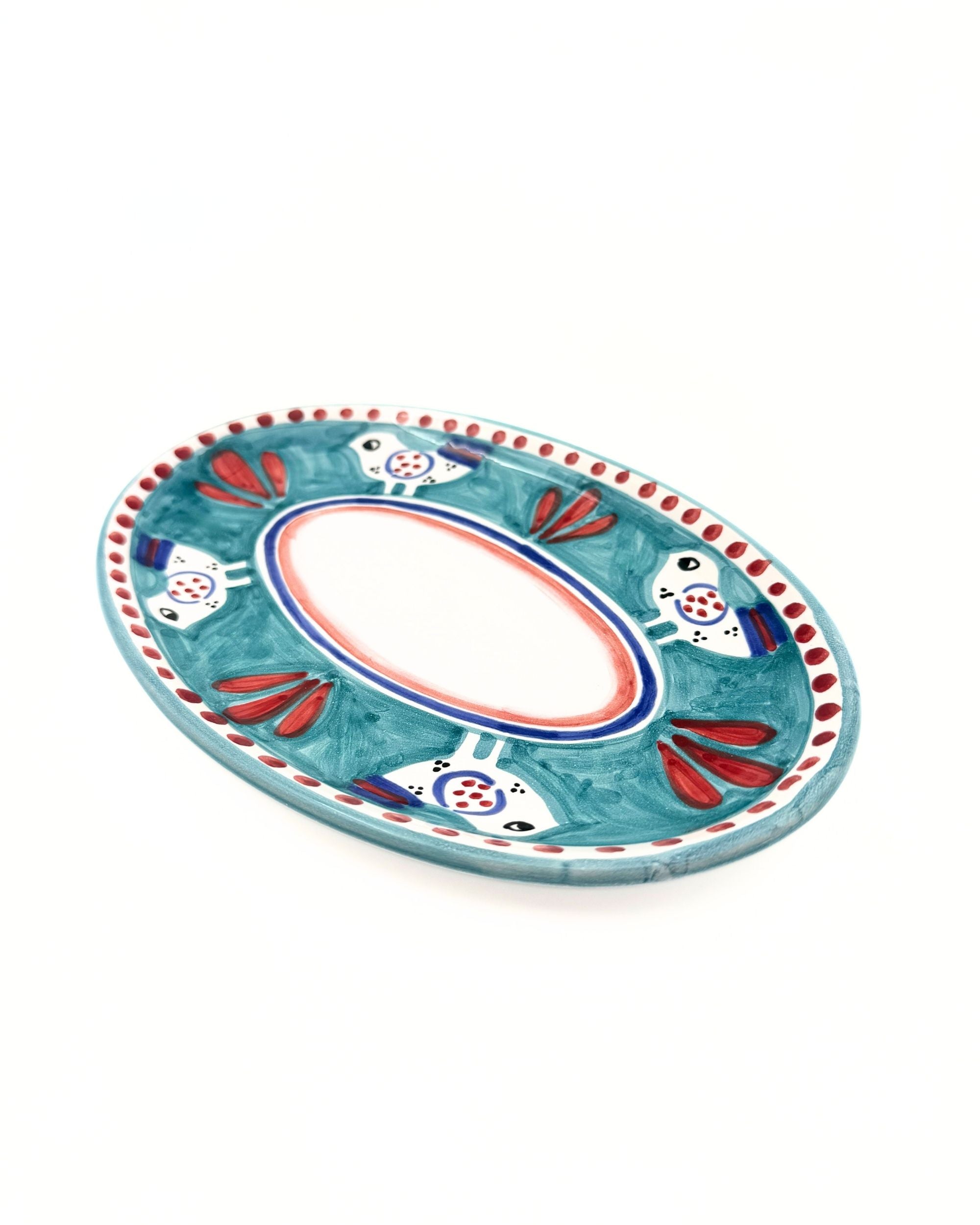 Detalj av Dipinto Ceramics Amalfi Ovalt Fat 24cm, blågrønn keramikk med rød og hvit fugledekor og røde prikker