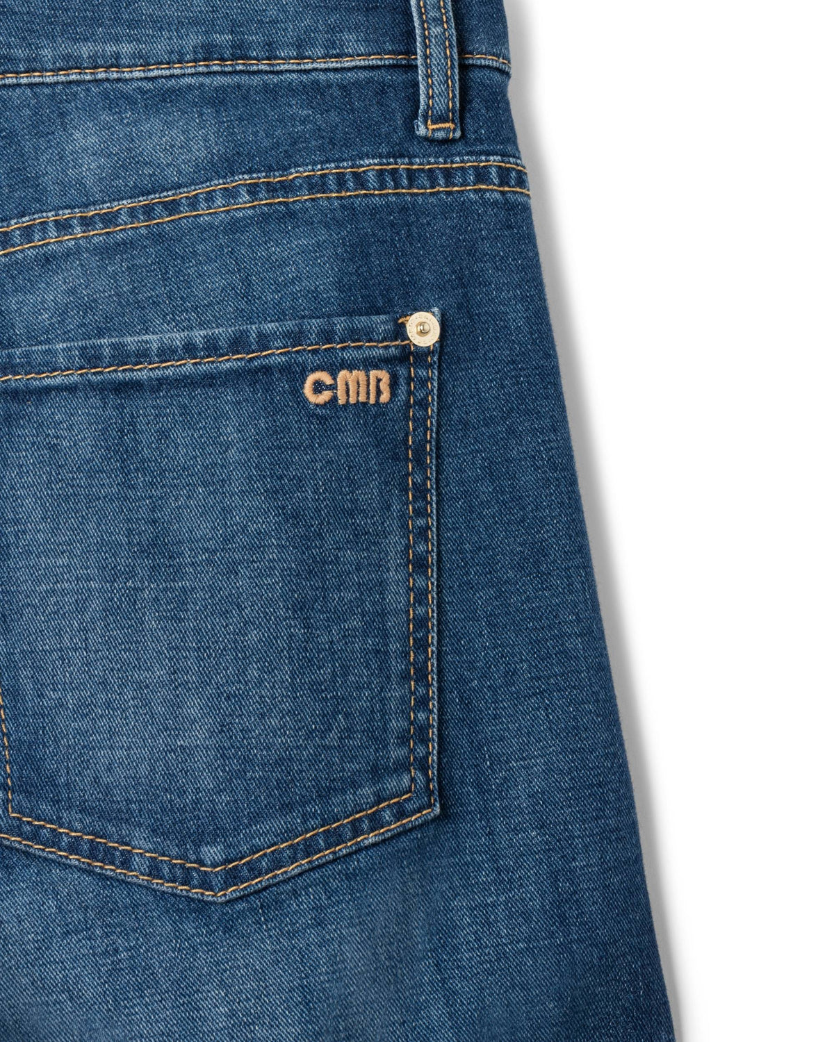 Cambio Aimee-bukse i blå denim. Detalj av lomme med gull CMB-logo og nagle.