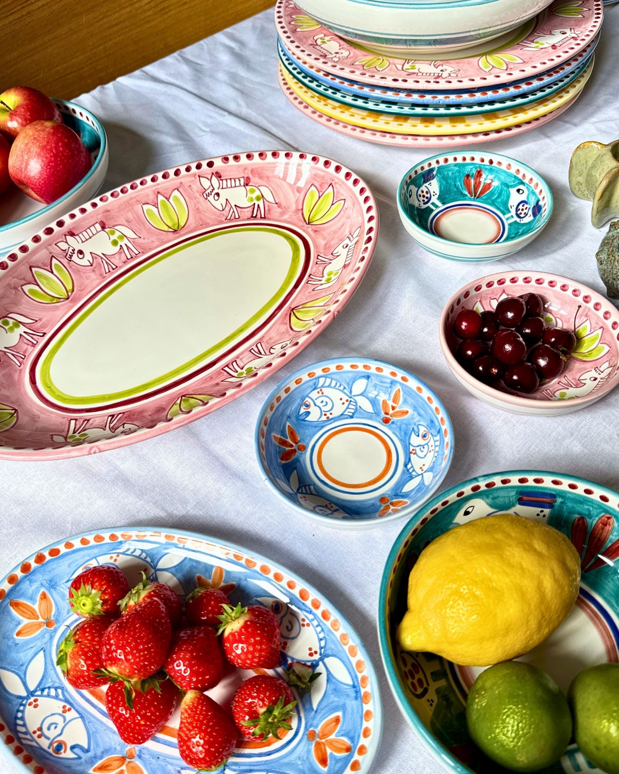 Detalj av Dipinto Ceramics Amalfi ovalt fat i rosa keramikk med håndmalte dyr og grønne detaljer i midten.