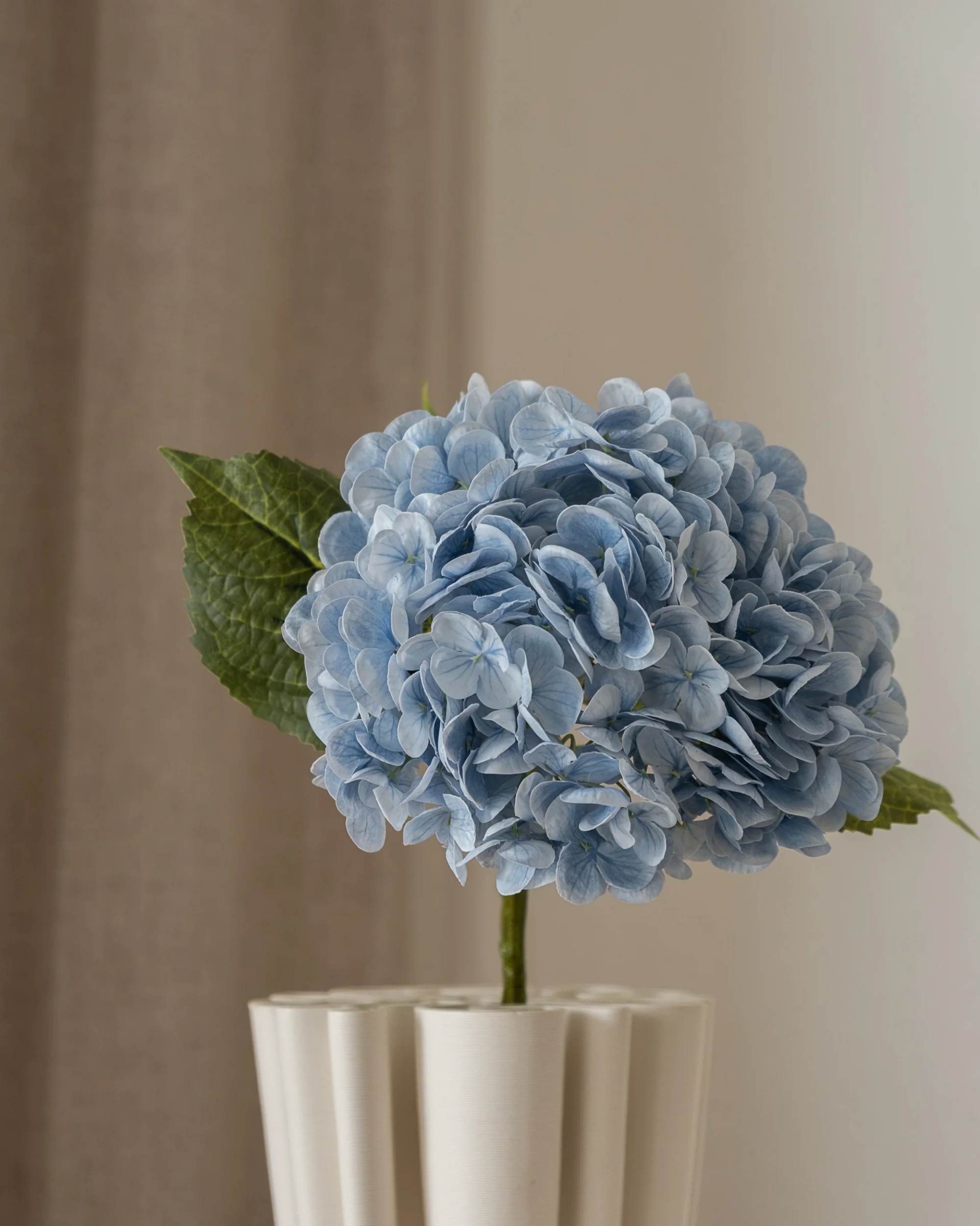 Amarante Hortensia kunstig blomst i nydelig lyseblått, med detaljerte kronblader og grønne blader