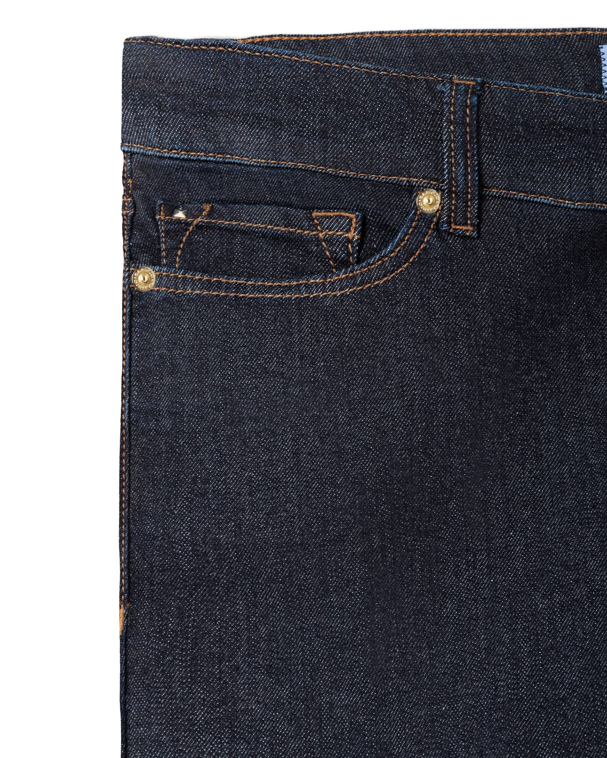 Detalj av Cambio Piper Long bukse, mørk blå denim med oransje sømmer, liten glidelåsdetalj og gylden nagle.