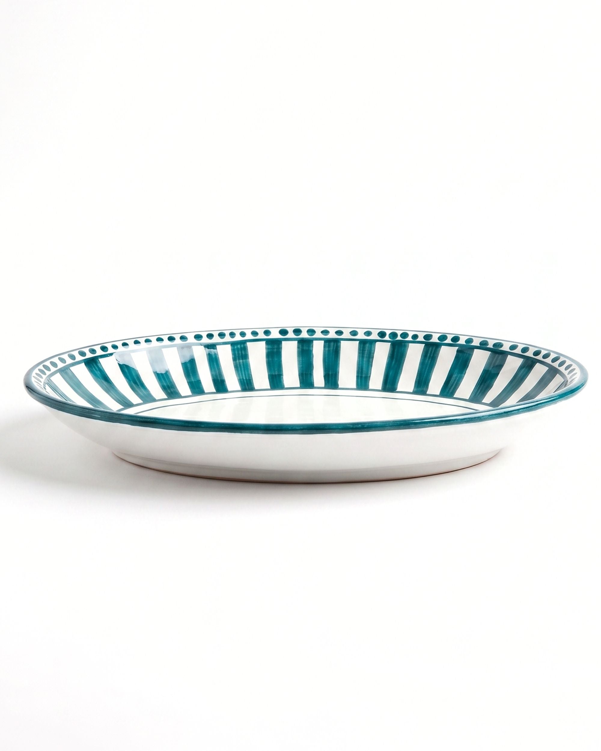 Dipinto Ceramics Linea Ovalt Fat, detalj av håndmalte mørkegrønne striper og prikker på hvit keramikkant