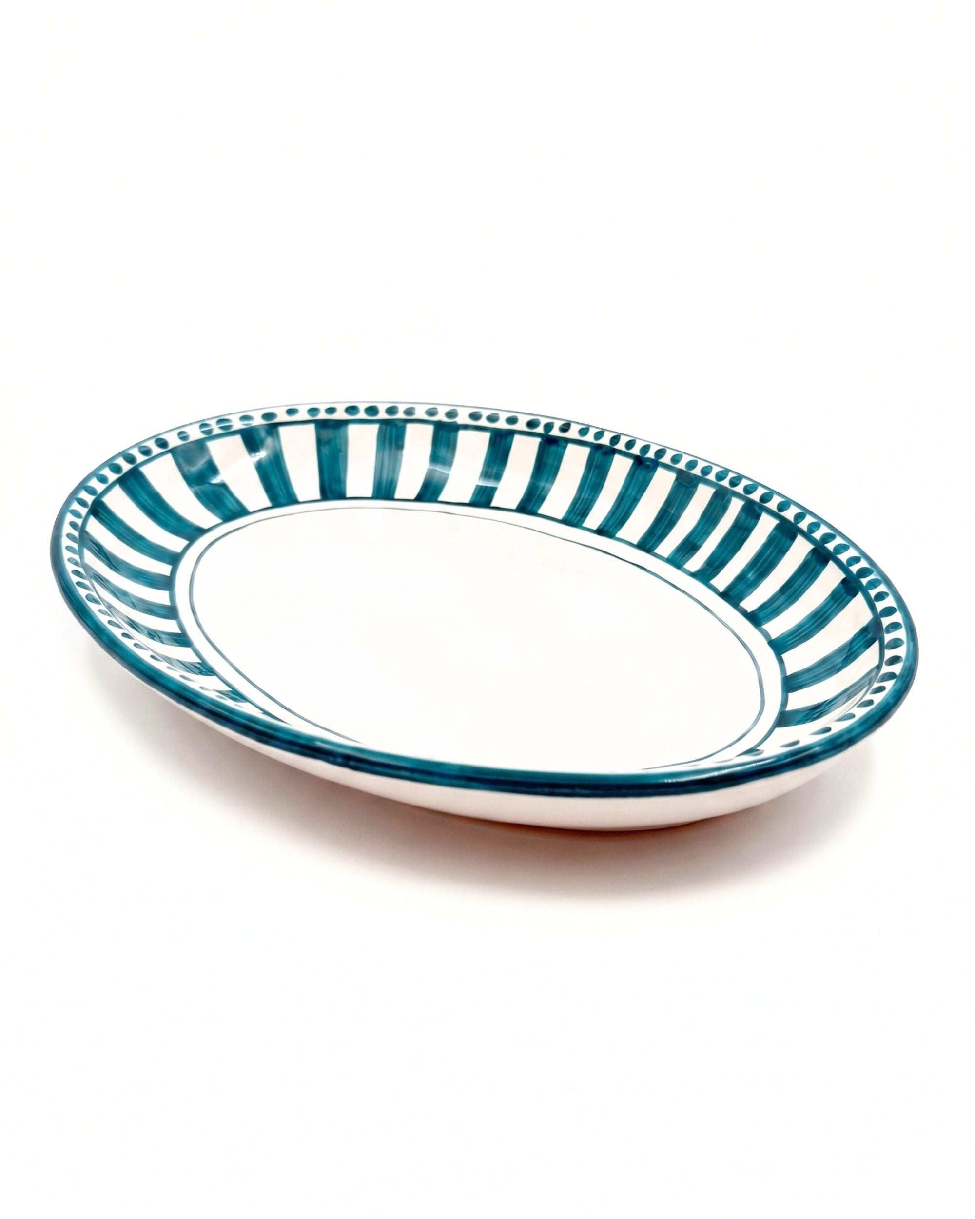 Linea Ovalt Fat fra Dipinto. Håndmalt keramikkfat, hvitt med tykke rette tealstriper og prikker langs kanten av fatet.