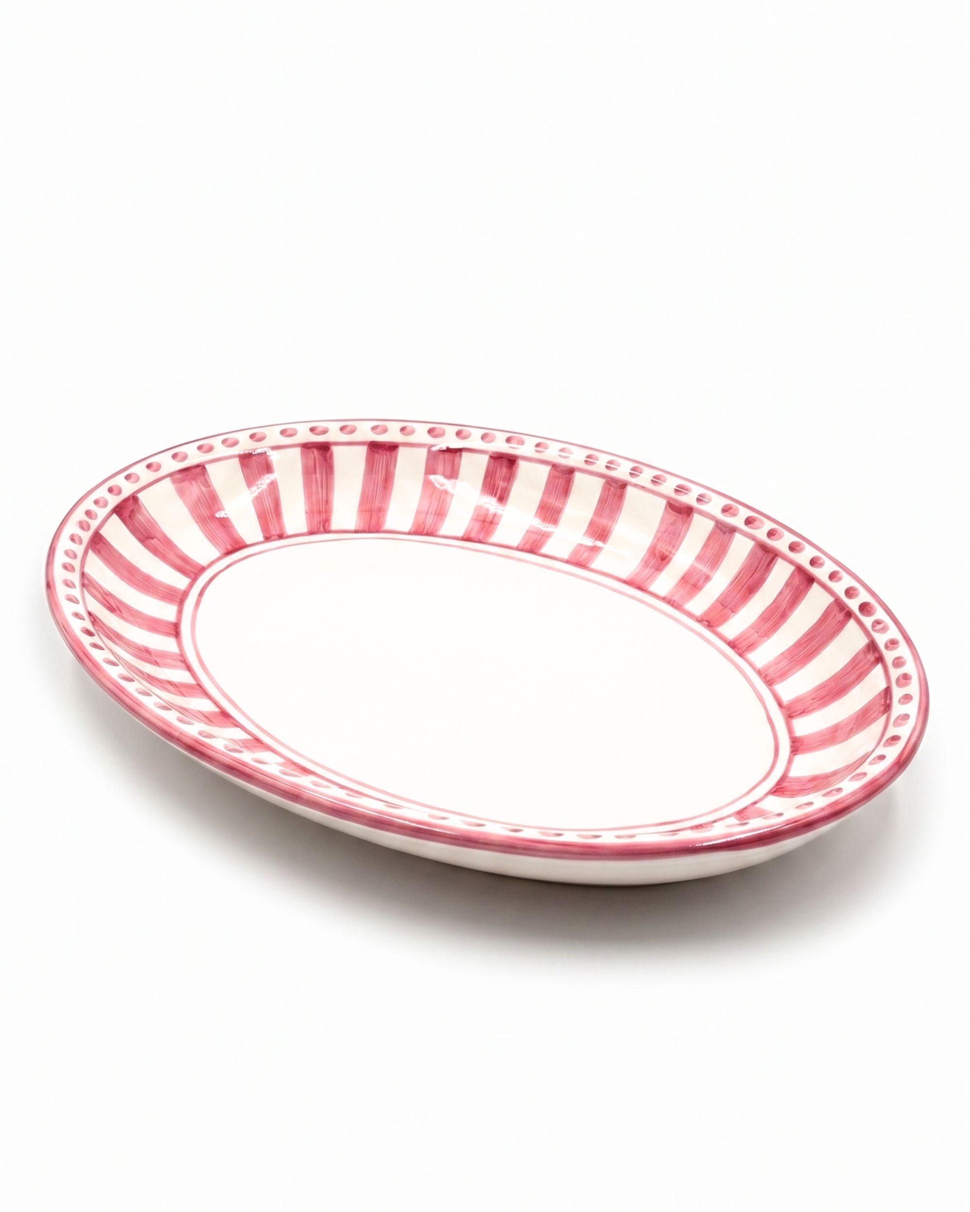 Dipinto Ceramics Linea Ovalt Fat, detaljbilde. Hvit keramikk med rødrosa stripete mønster og prikkekant.