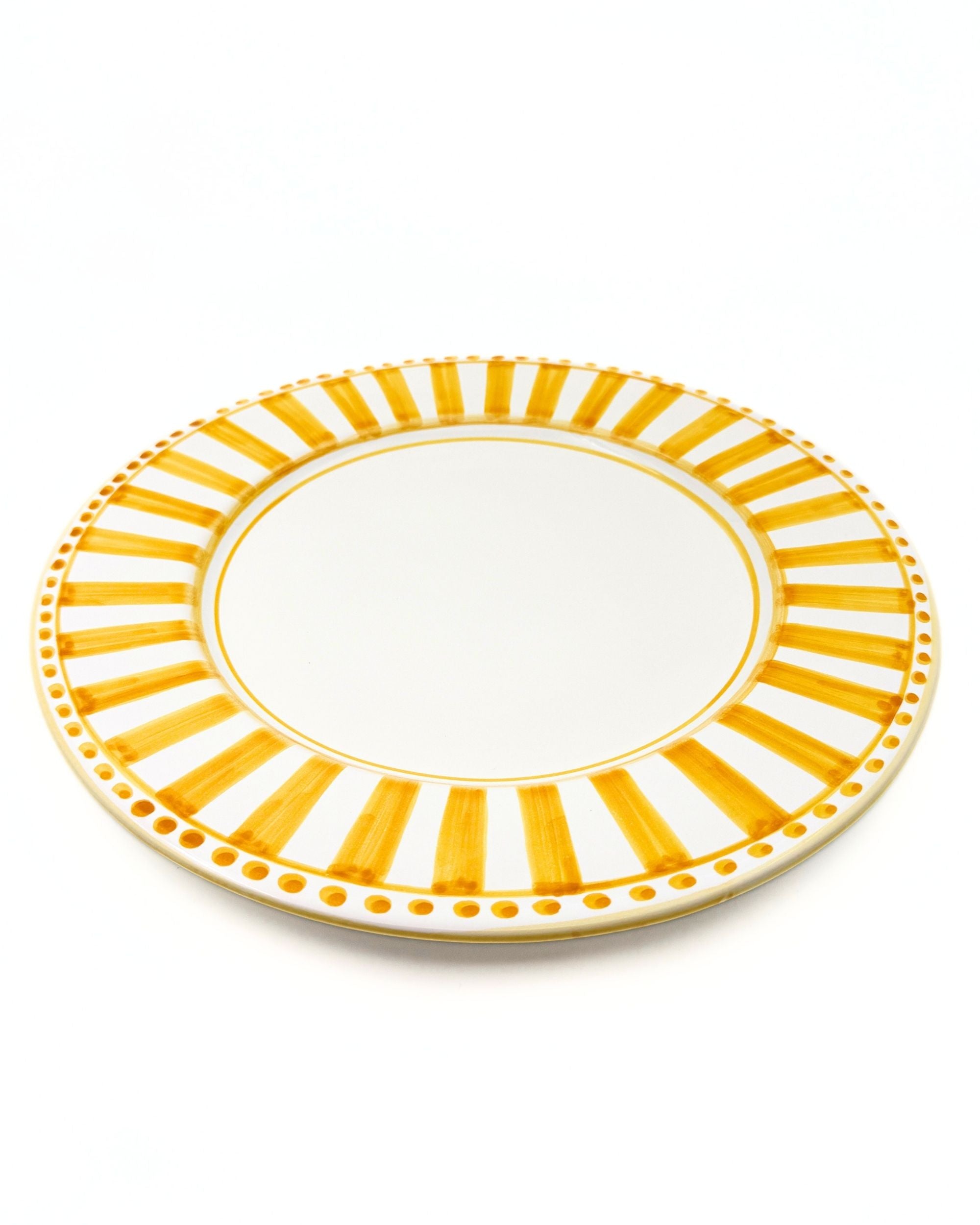 Linea Rundt Keramikkfat fra Dipinto Ceramics, detalj av håndmalte gule striper og prikker på hvit bakgrunn.