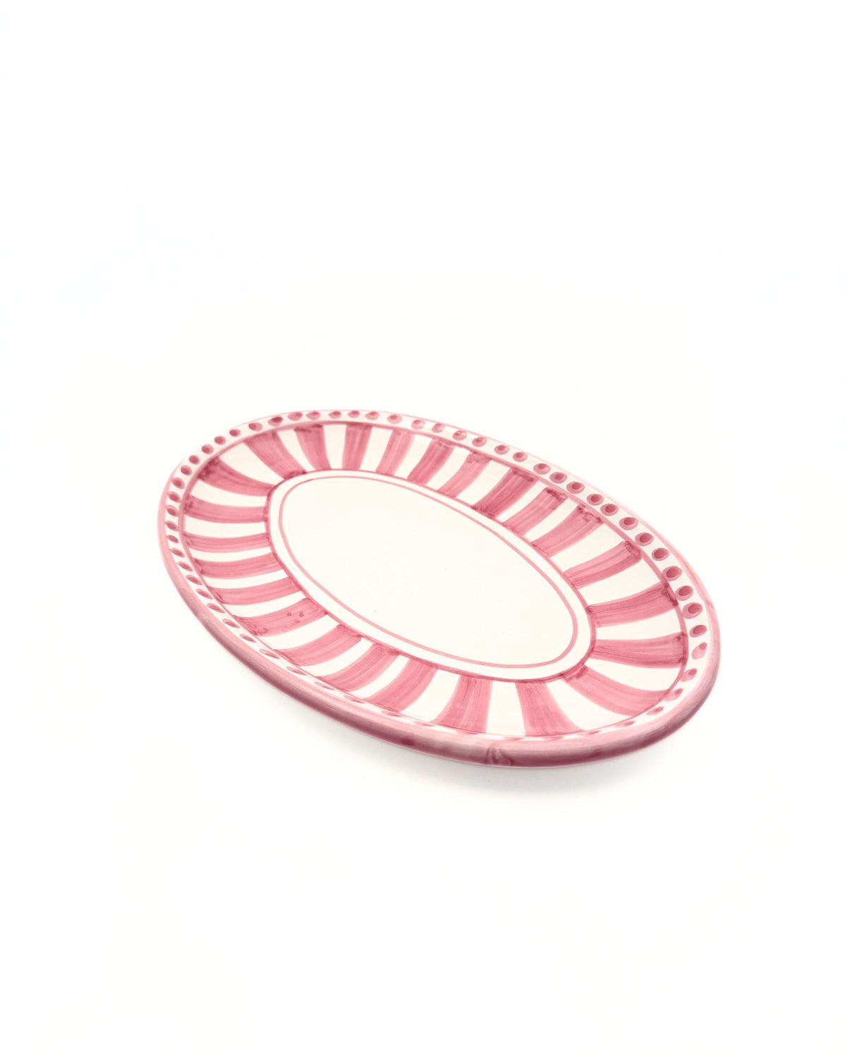 Detalj av Dipinto Ceramics Linea Ovalt Fat med håndmalte rosa striper og prikker på hvit keramikk.